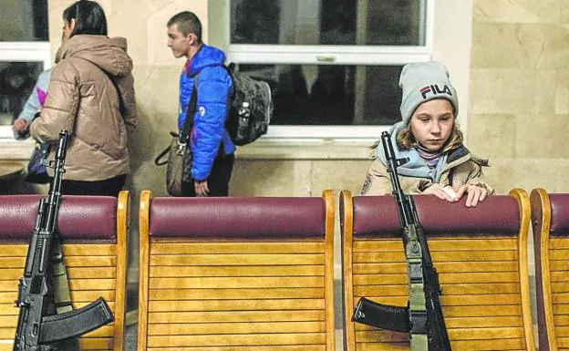A girl observes the weapons deposited in a Police station. 