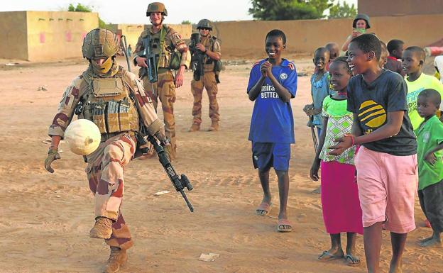 A French soldier plays with children in a village in Mali, before the French mission in the Sahel left the region earlier this year.