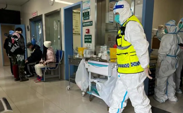 Security personnel in protective suits keep watch as doctors treat patients at Tongji Hospital in Wuhan. 