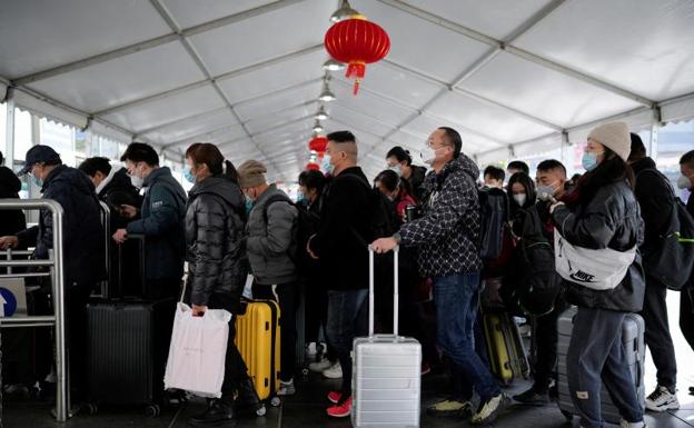 People walk with their luggage at a train station during the annual Spring Festival rush ahead of the Chinese Lunar New Year. 