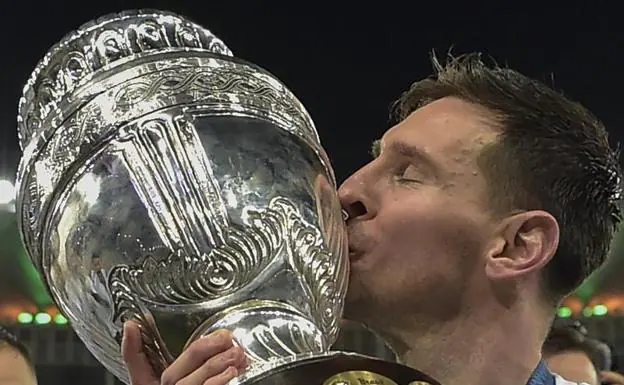 Leo Messi kisses the World Cup trophy. 